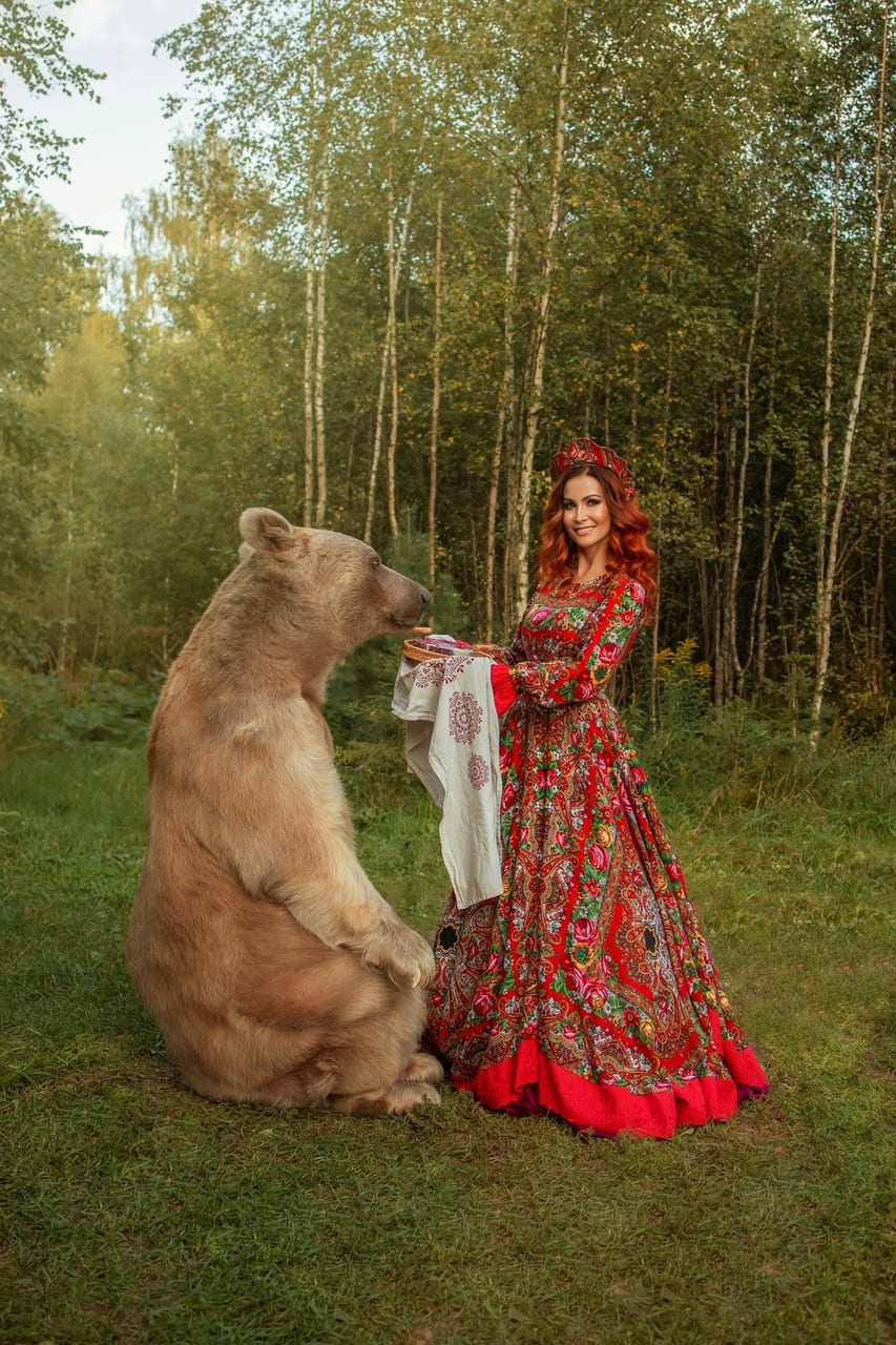 Фотосессия с бурым медведем Степаном в Москве — девушка в русском народном костюме обнимает ручного медведя в лесу