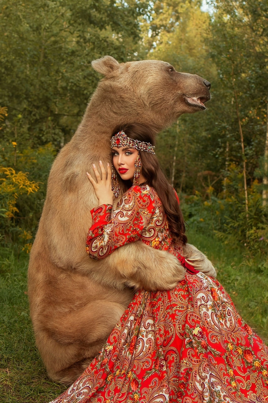 Обнимает медведя на фото